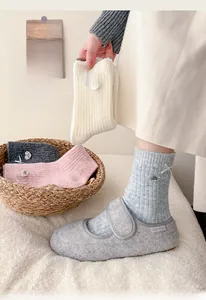 Detailed knit texture of wool crew socks with decorative bow and heart tag detail