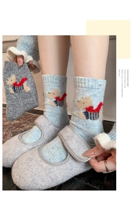 Detailed knit texture of wool socks featuring cute cartoon dog and red scarf patterns