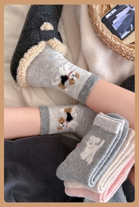 Close-up of thick wool blend socks with cute dog patterns in grey, beige, and pink colors