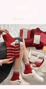 Detail of festive red and white striped knit cashmere socks in a cozy winter setting