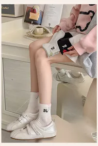 Close-up of cat embroidery and 3D pink heart details on cotton crew socks for women