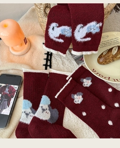 Detailed close-up of thick burgundy wool socks with cute animal pattern and frilly edges