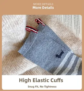 Macro shot of grey crew sock with striped cuff and navy dog embroidery detail