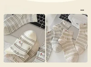 Détail de chaussettes en coton rayées avec étiquettes chiot mignon sur un bureau