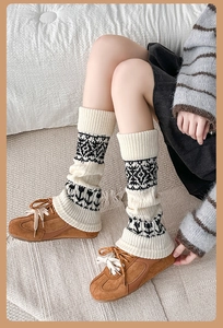 Close-up of thick knitted leg warmers with cream and black ethnic Fair Isle patterns