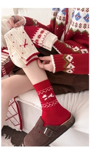 Detailansicht festlicher Wollsocken mit Schneeflockenmuster und roter 3D-Schleife