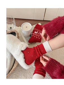 Detail von roten Wollsocken mit weißen Weihnachtsrentier- und Schneeflockenmustern