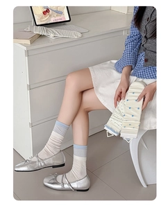 Detail of blue striped and white polka dot slouch socks with silver Mary Jane shoes