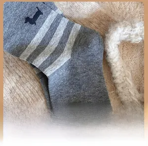 Detail of the reinforced heel on grey knitted socks with black puppy embroidery