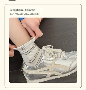 Détail de chaussettes blanches rayées élastiques avec écusson chien et baskets