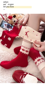 Detail der roten Weihnachts-Wollsocken mit Schneeflockenmuster und festlicher Schleife