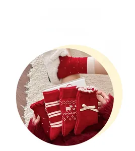 Detail von roten und weißen Wollsocken mit Rentiermustern und süßen Spitzenbögen