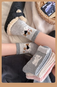 Close-up of cute cartoon dog embroidery on thick winter wool socks with ribbed cuffs