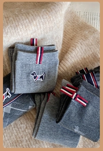 Detailed view of grey cotton socks featuring dachshund embroidery and tricolor woven labels