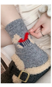 Detailed view of gray wool socks with cartoon puppy patch and fur slippers