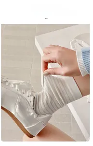 Detail showing the high elasticity and stretch of the striped white cotton mid-calf socks