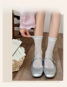Detailed shot of elastic mesh socks with heart patterns being stretched by hand