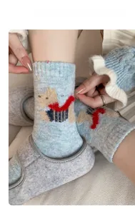 Detailed knit texture of light blue wool socks with a 3D cartoon dog embroidery