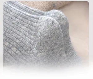 Detail of reinforced heel on thick light blue wool blend socks with knit texture