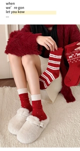 Details von roten Wollsocken mit Schneeflockenmustern und süßen Spitzenakzenten