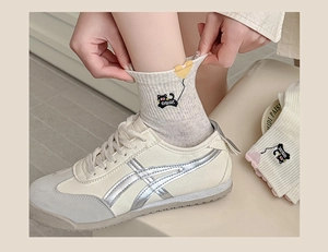 Detailed close-up of cute cat embroidery on light grey socks with elastic cuff detail