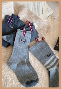 Detail of grey cotton socks featuring dachshund embroidery and iconic tricolor labels