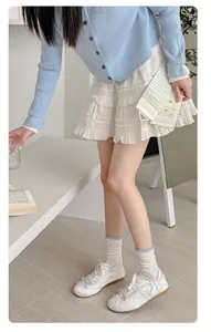 Detail showing white ruffle edge socks with polka dots paired with white dress and shoes