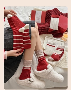 Close-up of red and beige striped cashmere knit socks with festive Christmas holiday styling