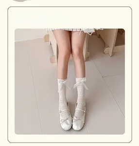 Detail of white mesh lace socks with elegant ribbon bows in a sweet ballet style