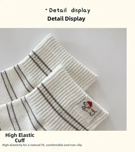 Détail de chaussettes en coton blanc côtelé avec broderie chien mignon et rayures marine