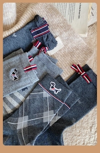 Detail of embroidered dachshund and tricolor stripe tag on cotton crew socks