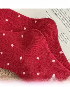 Detail von roten Wollsocken mit weißen Punkten, verstärkter Ferse und nahtloser Spitze