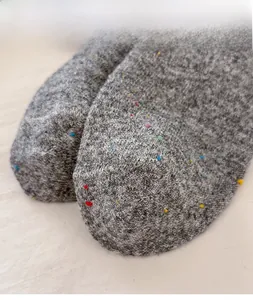 Close-up of gray wool blend socks featuring colorful polka dots and high elastic cuff