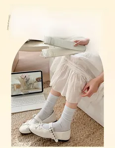 Close-up of thin mesh crew socks with bow hollow design and delicate ribbed texture