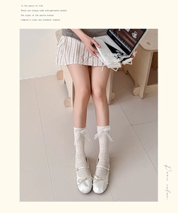 Detail of white lace hollow knee-high socks with silk bow and mesh texture details
