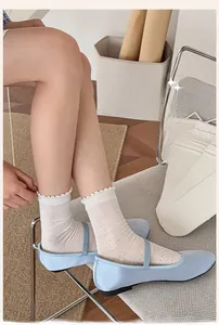 Détail de chaussettes hautes blanches en résille pointelle avec bordure en dentelle douce