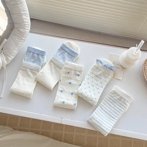 Five pairs of cream and light blue mid-calf socks with polka dots and stripes