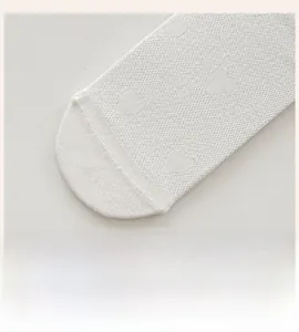 Detailed close-up of seamless toe and heart mesh pattern on white silk socks