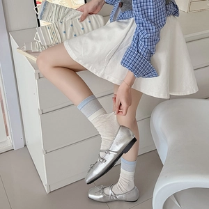Blue and white striped and polka dot mid-calf socks paired with silver Mary Jane shoes