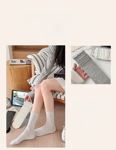 Detail view of ballet style ruffle trim crew socks in white, black and light grey colors