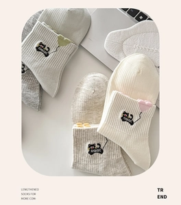 Detail showing cartoon cat embroidery and 3D heart on pastel cotton crew socks