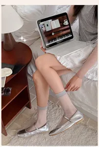 Detailed close-up of ultra-thin sheer beige crew socks for women in a cozy home setting