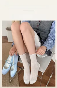 Détail de chaussettes mi-hautes blanc cassé avec bordure festonnée élastique pour femme