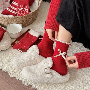 Rote Wollsocken mit weißer Schleife und Rüschen, kombiniert mit warmen Fleece-Hausschuhen