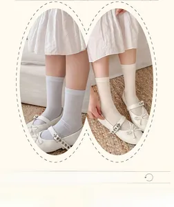 Detail of hollow bow-knot socks in light blue and beige with white Mary Jane shoes