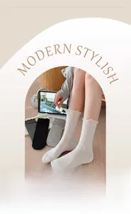 Close-up of ruffled cuff socks in white, gray, and black colors with elastic cotton texture