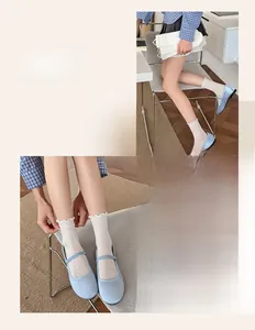 Gros plan de chaussettes en dentelle blanche avec ballerines Mary Jane bleu clair