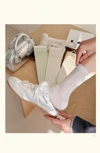 Detail of silk hollow out bow socks with fine ribbed texture in multiple soft colors