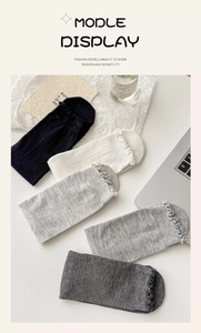 Detail of multi-color ballet style socks with ruffle edges in black, white and grey