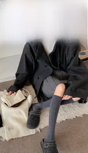 Dettaglio di calze a coste in misto lana grigio scuro, beige e color caffè da donna